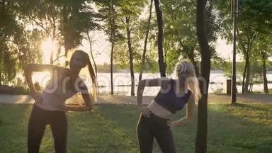 两位年轻女子在公园里做有氧运动、<strong>减肥</strong>、健身<strong>模特</strong>运动、镜头耀斑和美丽的景色